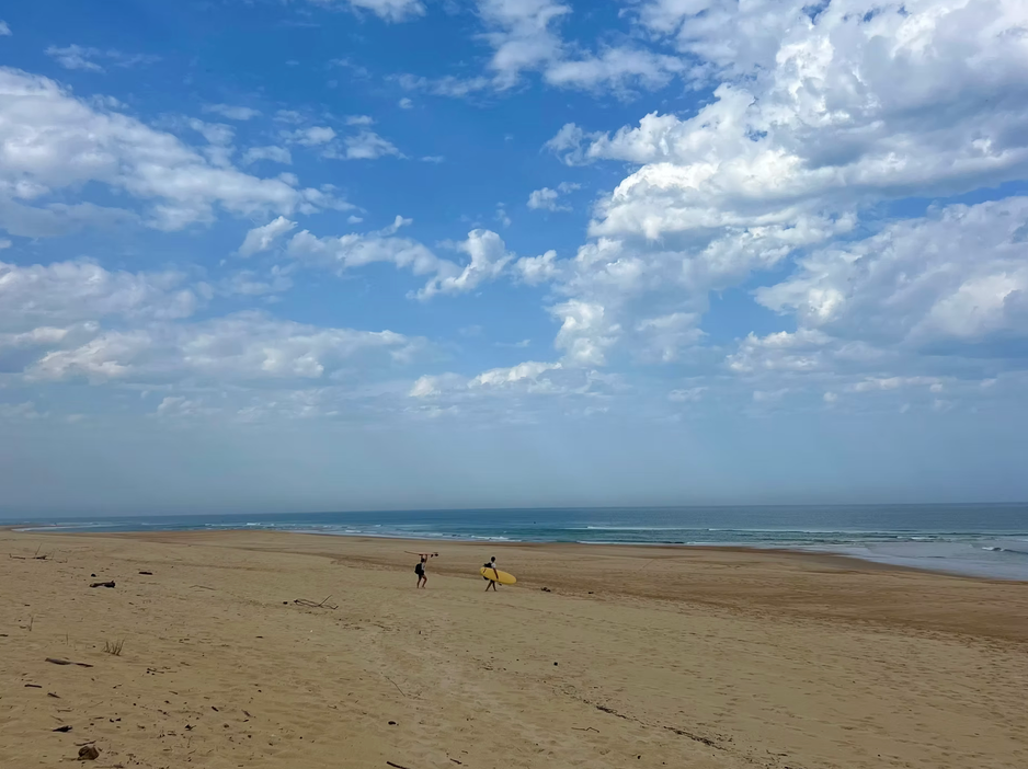 2 surfeurs se dirigeant vers les vagues sur une plage dans les Landes