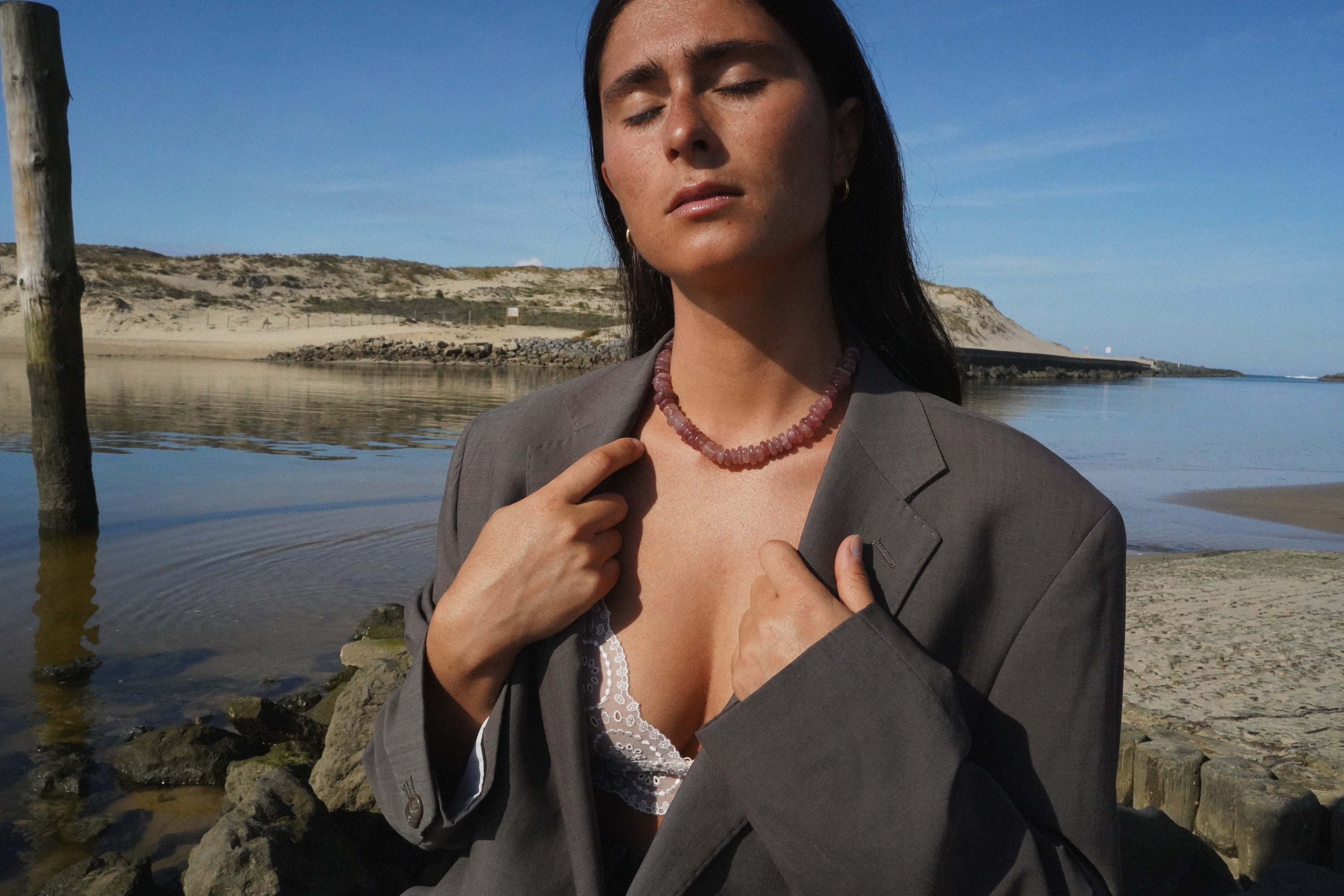 Collier fait main rose en pierres naturelles porté par une modèle sur une place