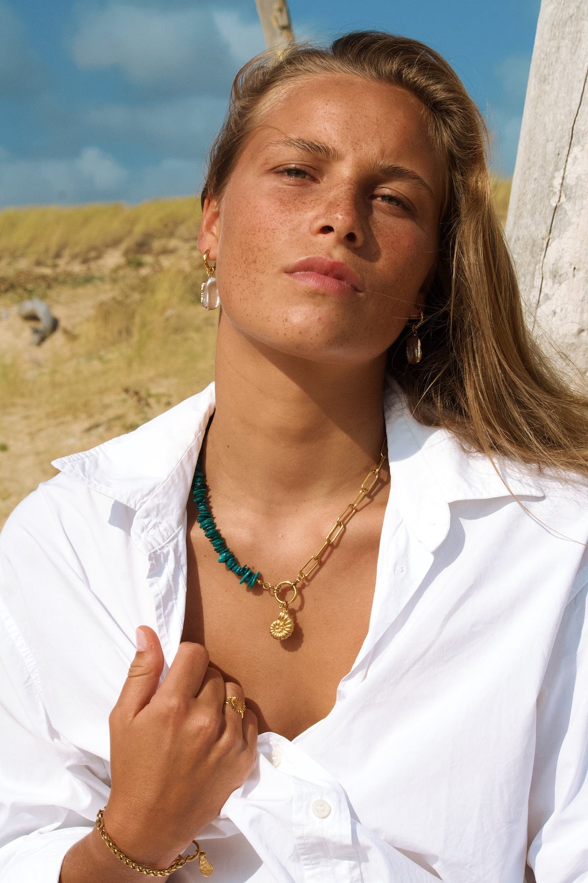 collier fait main en pierres naturelles et acier inoxydable porté par une modèle sur une plage dans les landes